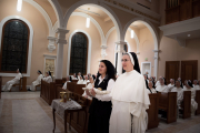 MOTHER ANNA GRACE AND THE YOUNGEST POSTULANT  PREPARE TO CARRY THE BABY JESUS TO THE CRIB.