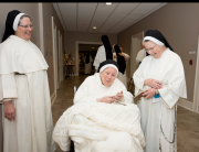 SISTER MARY LEONARD HOLDS A SMALL STATUE OF THE INFANT JESUS.