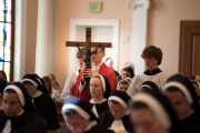 Good Friday: Father Chrismer bears the crucifix for veneration of the cross.