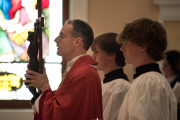 Good Friday: Father Chrismer bears the crucifix for veneration of the cross.