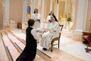 18-Each sister kneels before Mother Anna Grace to receive each part of the habit, during which time Mother recites a short prayer.