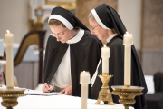 21-After professing the vows, the sister goes to the altar to sign the book on which she has written her vows.