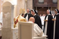 The four sisters carry the offertory gifts to Bishop Spalding. The four sisters carry the offertory gifts to Bishop Spalding.