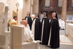 Before professing their vows, the sisters stand before the Bishop. Before professing their vows, the sisters stand before the Bishop.