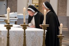 The sister signs her vows on the altar in the book of profession. The sister signs her vows on the altar in the book of profession.