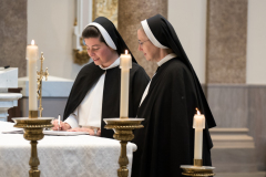 The sister signs her vows on the altar in the book of profession. The sister signs her vows on the altar in the book of profession.