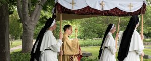 Father Chrismer carries the monstrance in the Corpus Christi procession